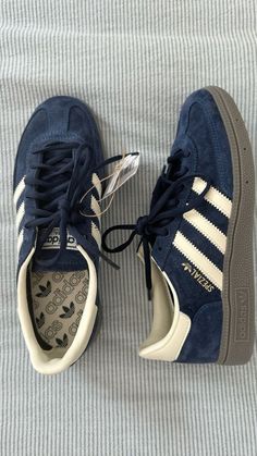 a pair of blue adidas sneakers sitting on top of a bed