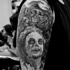 a man with a tattoo on his arm that has an image of a woman's face