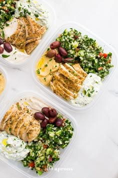 four plastic containers filled with food on top of a white countertop next to each other