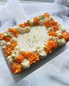 a birthday cake decorated with orange and white flowers