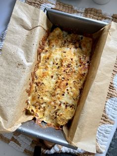 a casserole dish with cheese and other toppings in a paper wrapper