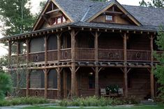 a large wooden house sitting in the middle of a forest