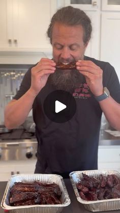 a man with a beard is eating food in tins on the kitchen counter top