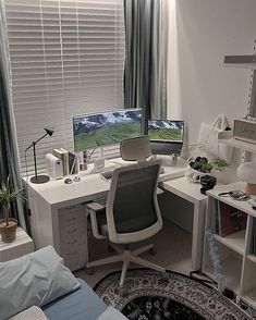 a bedroom with a bed, desk and computer on top of the desk in front of a window