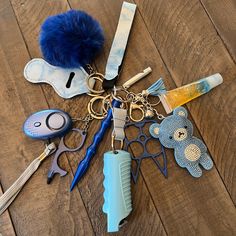 several different items are laying on the floor with one keychain and two pairs of scissors