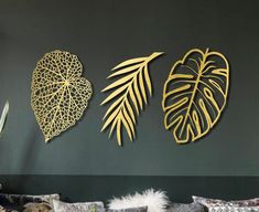 three metal leaves on the wall above a couch