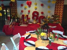 a table set up with red and yellow decorations