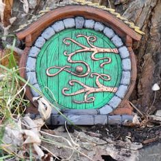 a green and brown clock sitting on the ground next to a tree