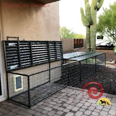 a black fenced in area with a ping pong table next to a cactus