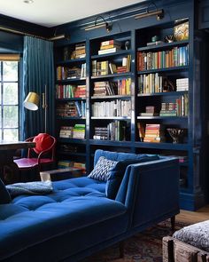 a living room filled with blue furniture and bookshelves