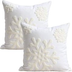 two white pillows with snowflakes on them