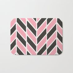 a pink and black bath mat with an arrow pattern on the bottom, in front of a white background