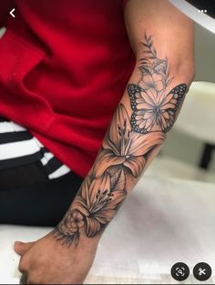 a woman's arm with flowers and butterflies on the back of her left arm