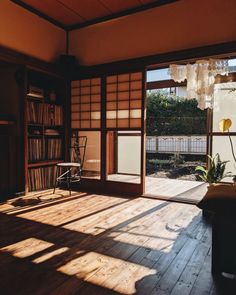 the sun shines through an open window into a room with wooden floors and walls