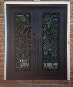 an iron door with two sidelights and glass panels on the front of a brick building