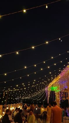 people sitting at tables under string lights