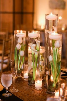 candles and flowers in glass vases on a table