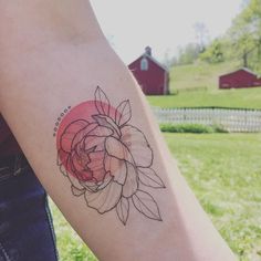 a woman's arm with a flower tattoo on the left side of her arm