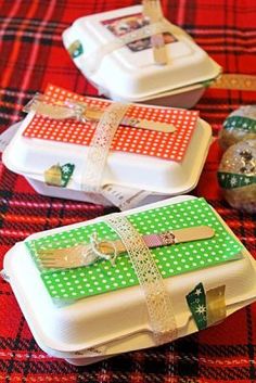 three white and green boxes with bows on them sitting on a plaid tablecloth covered table