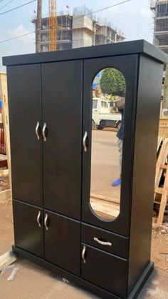 a tall black cabinet with mirrors on it's sides in the middle of construction