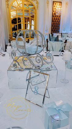 an elaborately designed chair sits on top of a table with blue napkins and wine glasses