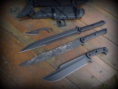 three knives are laying on the floor next to each other with their blades still attached