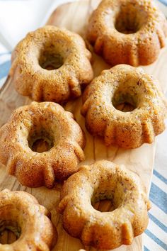 several donuts on a wooden board with blue and white table cloth