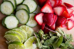 sliced strawberries, cucumbers and limes on a cutting board