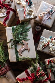 christmas presents wrapped in brown paper and tied with red ribbon on top of a wooden table