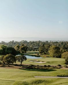 a golf course surrounded by trees and water