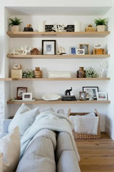 a living room filled with lots of shelves covered in pictures and books on top of them