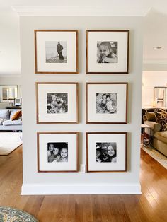 a wall with four pictures hanging on it's side and a couch in the background