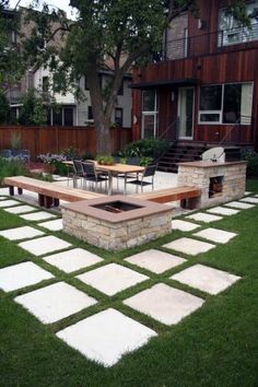 a backyard with grass and stone pavers on the ground, including a fire pit