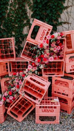 a pile of pink crates filled with flowers