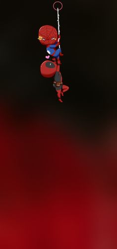 a spiderman hanging from a string in the air