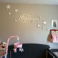 a baby's room decorated in pink and white with stars on the wall above it