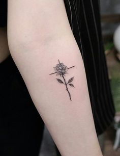 a small rose tattoo on the left arm