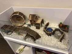 a display case filled with lots of fake wood and white snow covered ground next to scissors