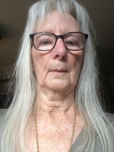 an older woman with long white hair and glasses