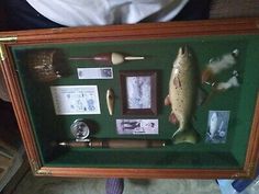 a display case with an assortment of fishing related items in it's shadow box