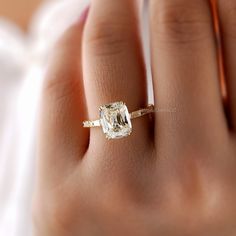 a woman's hand with a ring on it and a diamond in the middle