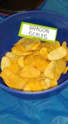 a blue bowl filled with potato chips and a sign that says dragon scales on it