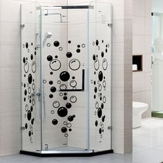 a bathroom with a glass shower stall and tiled flooring in the corner, next to a white toilet