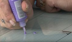 a person is doing something on the floor with a purple bottle in front of them