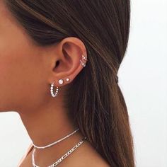 a close up of a person wearing some kind of earring with chains attached to it