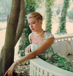 a woman sitting on top of a white bench