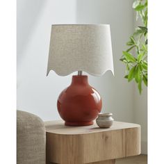 a red lamp sitting on top of a wooden table