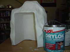 a can of paint sitting next to a white object on top of a wooden table