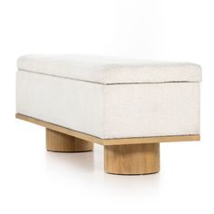 a white ottoman sitting on top of a wooden base