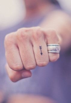 a woman's hand with a small tattoo on it